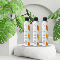 KenetikPro Strawberry Peach ketone energy drink bottles on a white display with tropical green leaves, designed for sustained energy and mental clarity.